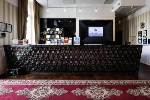 a bar in a room with a red rug at Mirage Medic Hotel in Budapest