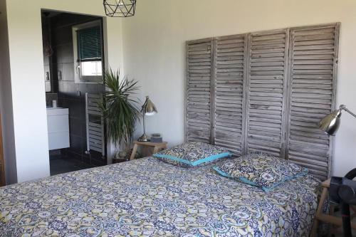 une chambre avec un lit avec deux oreillers dessus dans l'établissement Maison lumineuse & chaleureuse, à Saint-Romain-au-Mont-dʼOr