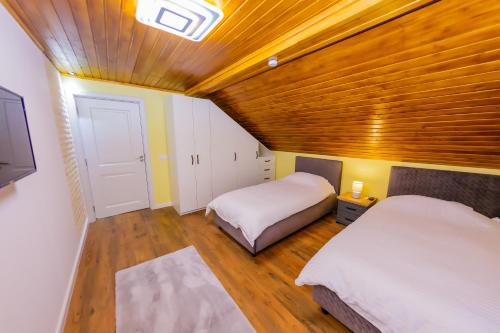 a bedroom with two beds and a wooden ceiling at Casa Edelweiss in Baia Mare
