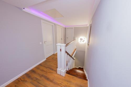 an empty hallway with a staircase with purple lighting at Casa Edelweiss in Baia Mare