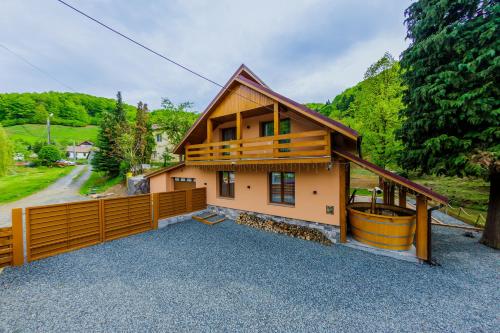 a house with a wooden fence and a yard at Casa Edelweiss in Baia Mare
