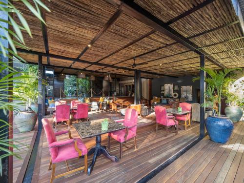 a patio with pink chairs and tables on a deck at The Residence in Johannesburg