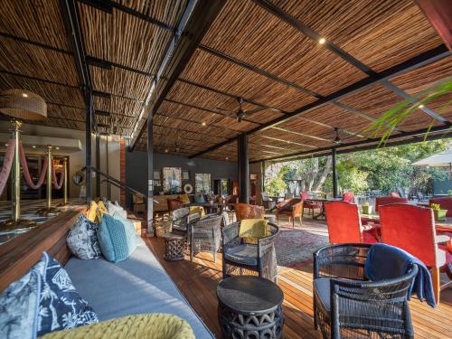 a living room with chairs and a couch and tables at The Residence in Johannesburg