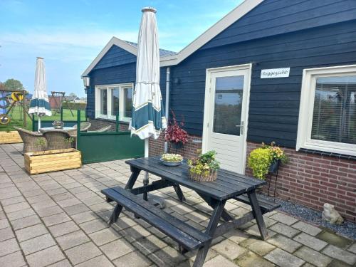 a patio with a picnic table and an umbrella at Charming house with garden in rural area Hellendoorn in Hellendoorn