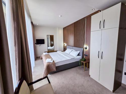a hotel room with a large bed and a mirror at Sonio Boutique Hotel in Mamaia