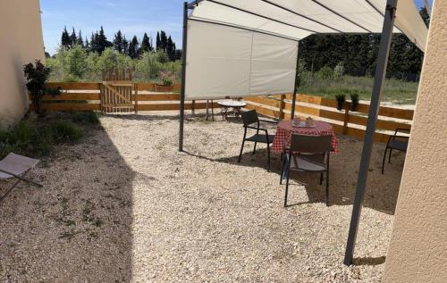 une table et des chaises sous une tente blanche dans l'établissement Gîtes Violettes et Amandier, à Violès