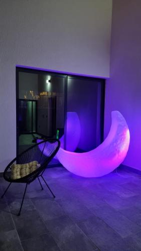 a room with a tub and a chair and purple lights at Vila MOON in Bezdead