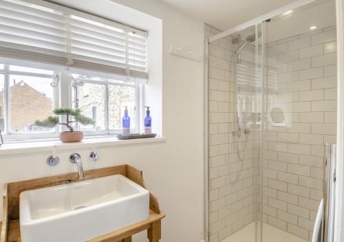 a bathroom with a sink and a shower at Fishermans Cottage in Wells next the Sea