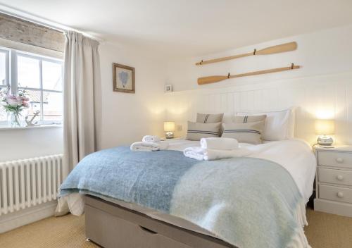 a bedroom with a large bed with towels on it at Fishermans Cottage in Wells next the Sea