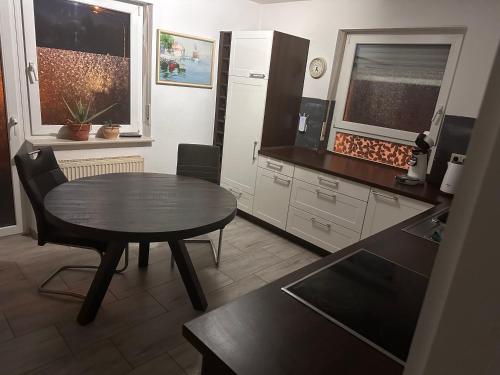 a kitchen with a table and a small table in a room at Schönes Zimmer in Offenburg