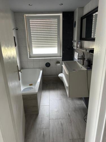 a bathroom with a sink and a toilet and a window at Schönes Zimmer in Offenburg