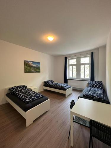 pokój z dwoma łóżkami i stołem w obiekcie Ar Living Frankfurt Königsteinerstr w Frankfurcie nad Menem