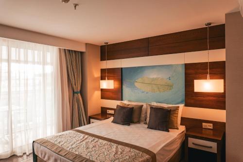 um quarto de hotel com uma cama e uma janela em Adella Side Hotel em Side