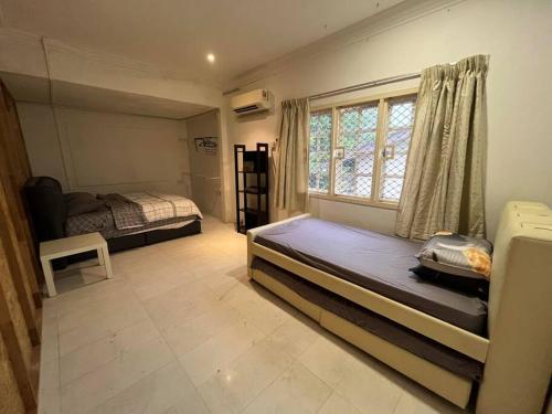 House of David - Bungalow at SS2 Petaling Jaya في بيتالينغ جايا: غرفة نوم بسريرين ونافذة
