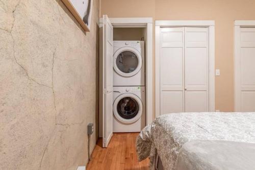 a laundry room with a washer and dryer next to a door at Chic Downtown Retreat - Rooftop Oasis in Bangor