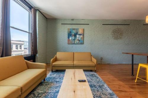 a living room with two couches and a coffee table at Chic Downtown Retreat - Rooftop Oasis in Bangor