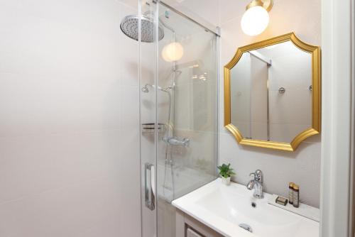 une salle de bain avec un lavabo et une douche avec un miroir dans l'établissement La Demeure du Chevalier d'Argent- parking gratuit, à Carcassonne