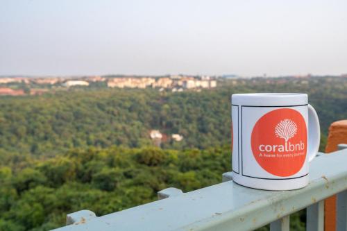 a cup of colombia sitting on top of a railing at 2BHK 10 min drive to GOI airport & beach at Dabolim in Vasco Da Gama