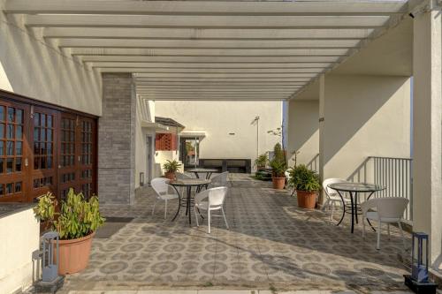 an outdoor patio with tables and chairs and plants at 2BHK 10 min drive to GOI airport & beach at Dabolim in Vasco Da Gama
