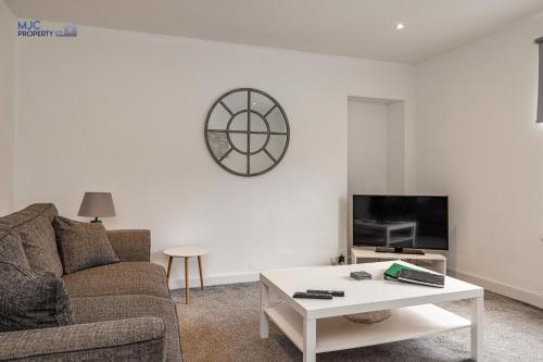 a living room with a couch and a coffee table at Town Centre Apartment in Hawick