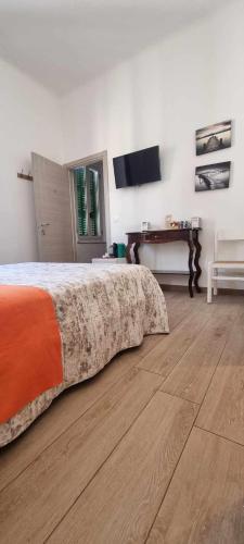 a bedroom with a bed and a table and a television at B&B D'AMARE in Cupra Marittima