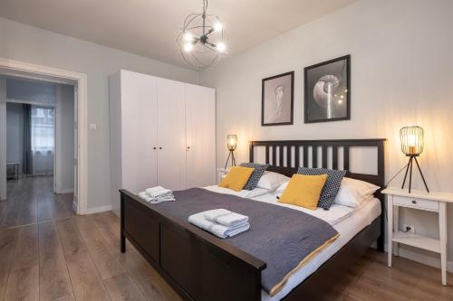 a bedroom with a large bed with yellow pillows at 29 Gdynia Centrum - Apartament Mieszkanie dla 4 os in Gdynia