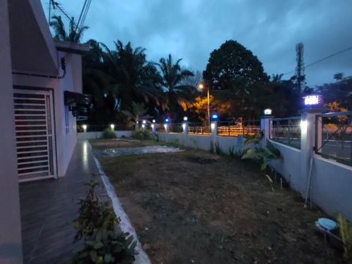 a backyard of a house at night with lights at Swedish Style Homestay in Teluk Intan