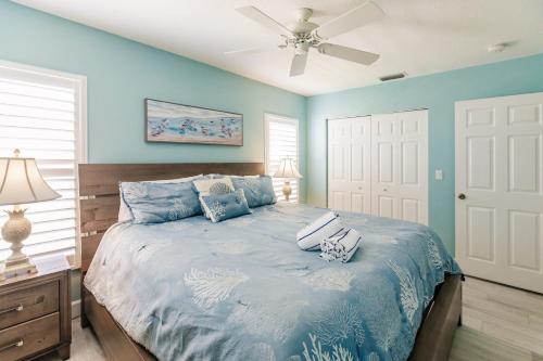 Schlafzimmer mit einem Bett mit blauen Wänden und einer Decke in der Unterkunft Villa 2 - Aloha Kai Vacation Villas in Siesta Key
