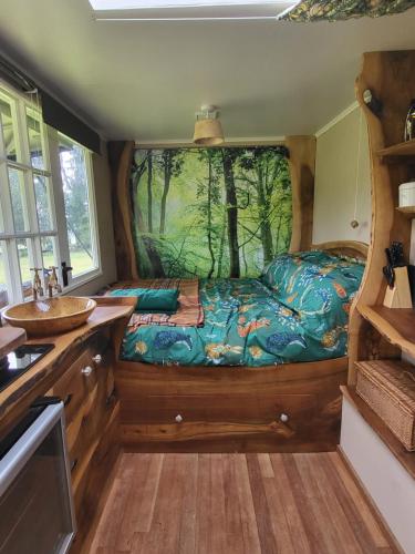 a bedroom with a bed with a painting on the wall at Courtlands farm camping and glamping in Canterbury