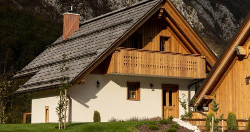 een huis met een houten dak en een balkon bij PRIVILLAGE Stare - B&B in Bohinj
