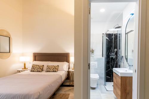 a bedroom with a bed and a shower and a sink at Arco de la Seda - Hotel Boutique in Seville