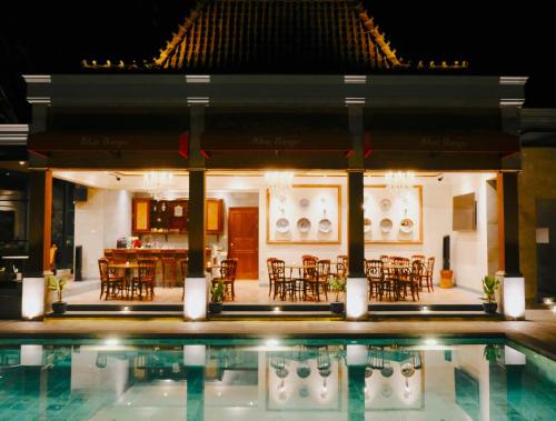 a pool in front of a restaurant at night at Dandaman villa in Yogyakarta