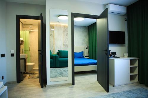 um quarto com uma cama azul e um espelho em Riverside Burabay Hotel em Borovoye