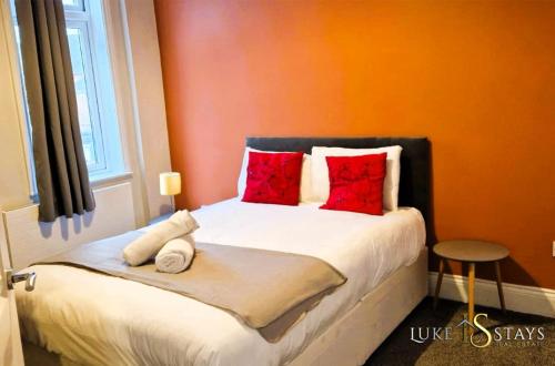 a bedroom with a bed with red pillows at Luke Stays - Welbeck Road in Old Walker