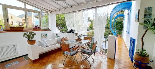 uma sala de estar com uma mesa e cadeiras numa varanda em Hotel Poseidon em Lipari