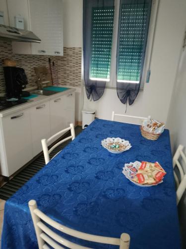 une table bleue avec deux assiettes dans une cuisine dans l'établissement Maison Salerno, à Salerne