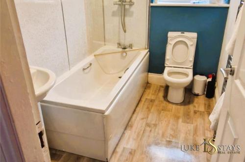 a bathroom with a toilet and a tub and a sink at Luke Stays - Welbeck Road in Old Walker