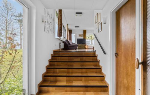 a staircase in a home with white walls and wooden floors at Lovely Home In Hesselager in Hesselager
