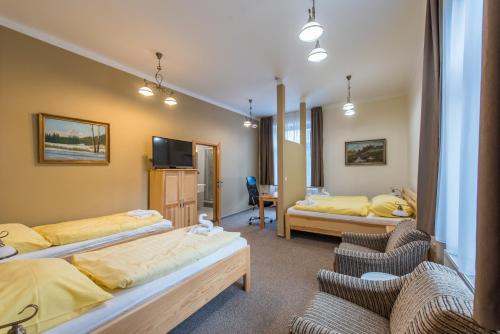 um quarto de hotel com duas camas e duas cadeiras em Penzion Vila Machů em Kopřivnice