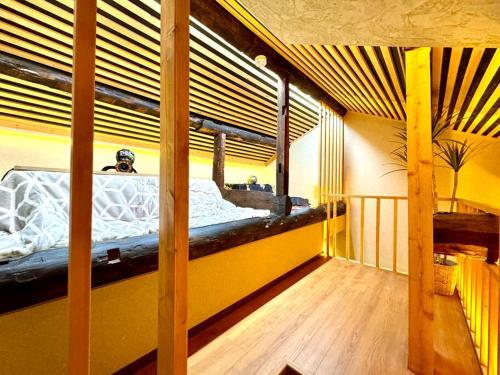 a bedroom with a bunk bed in a yellow room at 螢居- 3層100坪別墅 心齋橋道頓堀2站 in Osaka