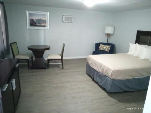 Habitación de hotel con cama, mesa y sillas en Homes -N - Courts en Sanford