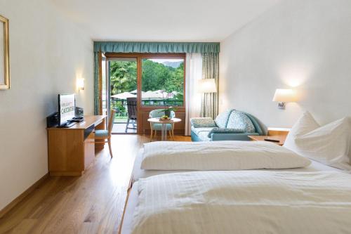 a hotel room with a bed and a desk and a chair at Hotel & Spa Cacciatori in Cademario