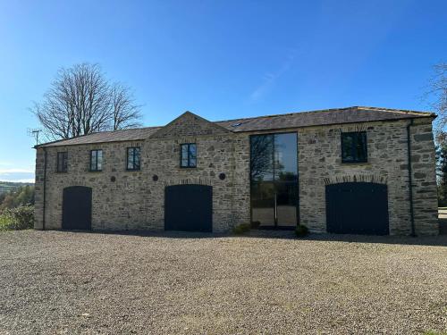 a brick house with two garage doors on a driveway at The Hayloft in Strabane