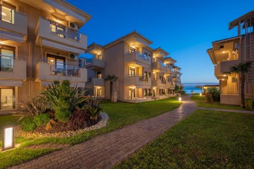 an apartment building at night with the ocean in the background at Alkioni By The Sea in Siviri