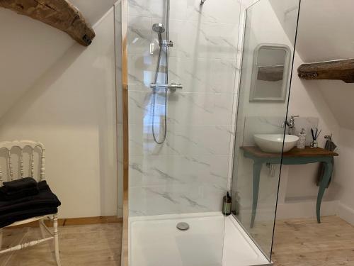 a shower with a glass door in a bathroom at Charming converted Granary in Capelle-lès Hesdin