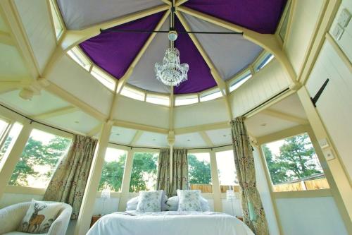 ノリッジにあるThe Folly - one off luxury Glamping accommodationのベッドとシャンデリアが備わる広い客室です。