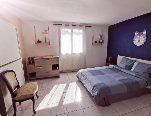 a bedroom with a bed and a blue wall at Petite maison cosy 4 couchages à 700 m de la plage in Torreilles