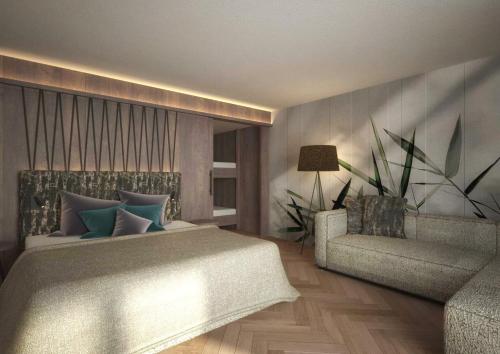 una camera da letto con letto e divano di Majestic Hotel & Spa Resort a Brunico