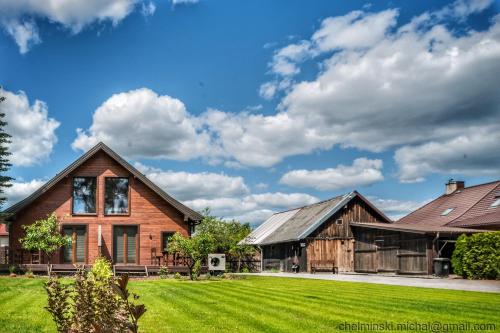 una casa con un césped verde delante de ella en Dom Płociczno-Osiedle koło Suwałk, 