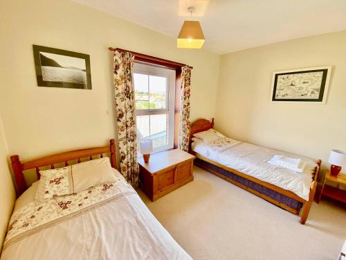 a bedroom with two beds and a window at Maytime Cottage in Whitwell